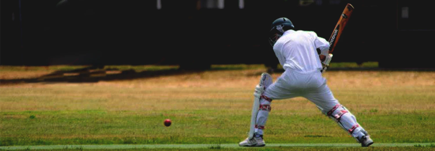 A Malvern Valley batter completes a back-foot shot as the ball runs away square across the outfield.
